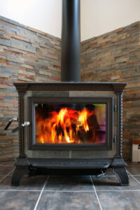 Visit Our Stove Store in Elkton - Elkton MD - Ace Chimney Sweeps gray stove against stone wall